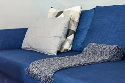 a blue couch with a pillow and a blanket at GuestReady - Miragaia Rooftop in Porto