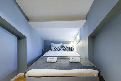 a bedroom with a large bed with blue walls at GuestReady - Miragaia Rooftop in Porto