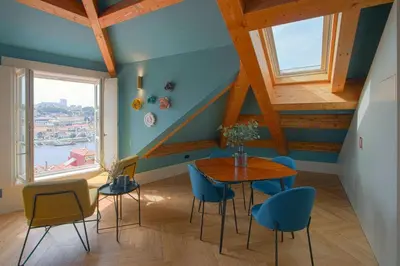 a dining room with a table and blue chairs at HM - Infante Riverside Apartment R in Porto