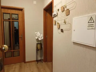 a hallway with a door and a vase of flowers at Gaia Douro Apartment in Vila Nova de Gaia