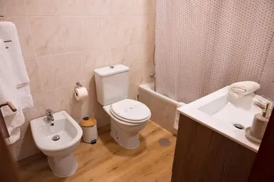 a bathroom with a white toilet and a sink at Gaia Douro Apartment in Vila Nova de Gaia
