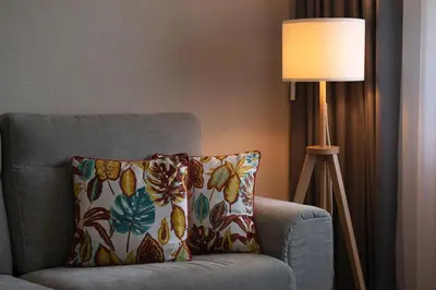 a pillow sitting on a chair next to a lamp at Gaia Douro Apartment in Vila Nova de Gaia