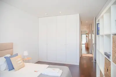 a bedroom with white cabinets and a bed in a room at Liiiving in Porto - Carlos Alberto Apartment in Porto