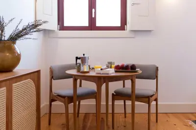 a table with two chairs and a bowl of fruit on it at Tripas Coração Taipas Historical Center in Porto