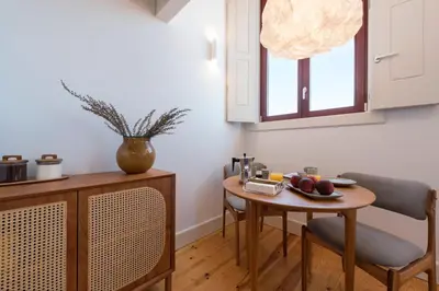 a kitchen with a table and chairs and a small table with fruit on it at Tripas Coração Taipas Historical Center in Porto