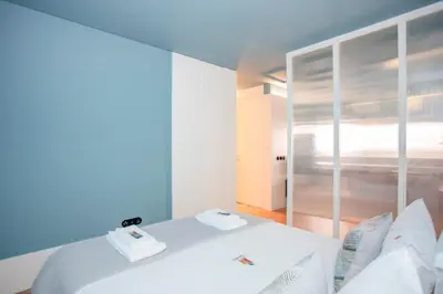 a white bed in a room with a window at Liiiving in Porto - Ribeira Design Apartment in Porto