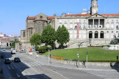 an old building with a green lawn in front of a street at HM - Infante Riverside Apartment M in Porto
