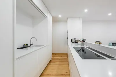 a kitchen with white cabinets and a sink at GuestReady - Green Bay Garden in Porto