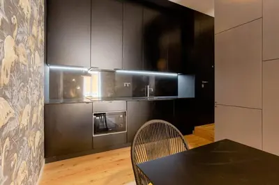 a kitchen with black cabinets and a black table and chairs at BOUTIQUE Rentals-Art & Charm II Apt w/ Terrace in Porto
