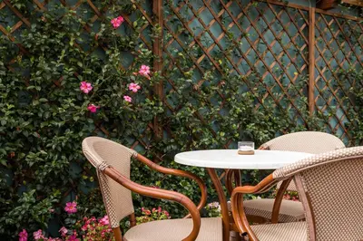 a table and chairs with pink flowers and a fence at Legends House by Sweet Porto in Porto