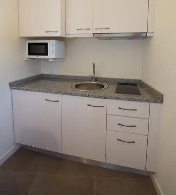 a white kitchen with a sink and a microwave at GuestReady - Catorze de Outubro Houses 423 in Vila Nova de Gaia