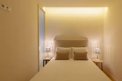 a bedroom with a large white bed with two lamps at GuestReady - Catorze de Outubro Houses 423 in Vila Nova de Gaia