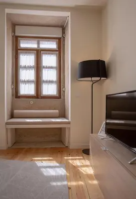 a room with a window with a bench and a lamp at GuestReady - Catorze de Outubro Houses 423 in Vila Nova de Gaia