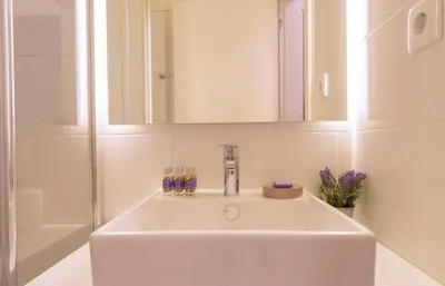 a white sink in a bathroom with a mirror at GuestReady - Catorze de Outubro Houses 423 in Vila Nova de Gaia