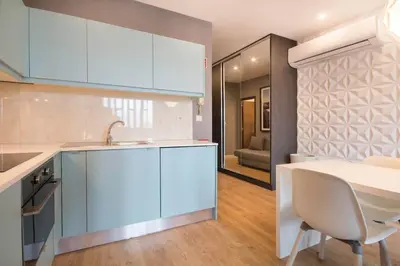 a kitchen with blue cabinets and a white table at 447 Galé Apartment wifi, parking in Porto