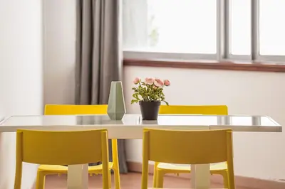 a dining room table with yellow chairs and a vase with flowers at Travel & Live Aliados Apartment in Porto