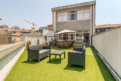 a patio with grass and chairs on a balcony at Travel & Live Aliados Apartment in Porto
