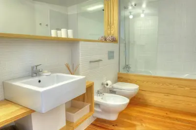 a bathroom with a white sink and a toilet at Three Houses & Bedrooms in Porto