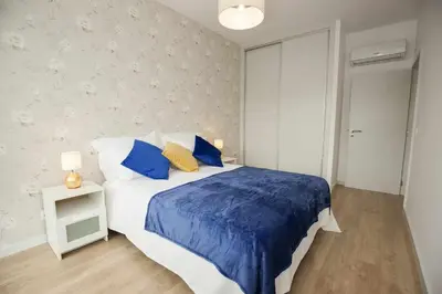 a bedroom with a large bed with blue and yellow pillows at Golden & Blue House, o seu novo espaço no Porto in Porto