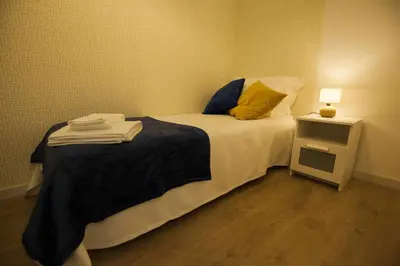a small bedroom with a bed and a night stand at Golden & Blue House, o seu novo espaço no Porto in Porto