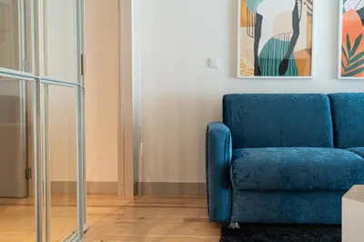 a blue couch in a living room with a painting at Shiny Porto in Porto
