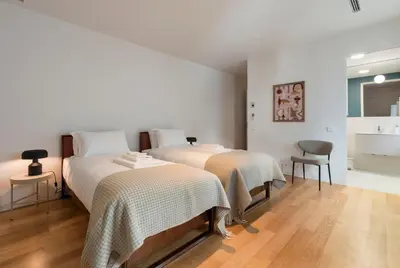 two beds in a room with white walls and wooden floors at Tripas-Coração, Santa Catarina in Porto