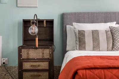 a bedroom with a bed and a night stand with a lamp at Carpe Diem Apartments in Porto