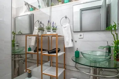 a bathroom with a toilet and a sink and blue tiles at Avenue View Rooms - Guest House in Porto