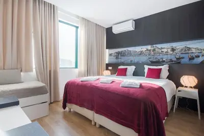 a bedroom with a large bed with a red blanket at 607 Galé Apartamento Wi-Fi, estacionamento in Porto