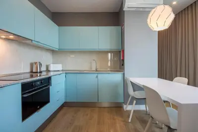 a kitchen with blue cabinets and a table with chairs at 607 Galé Apartamento Wi-Fi, estacionamento in Porto