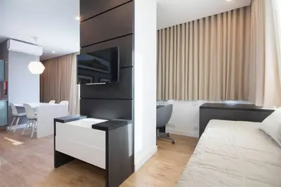 a bedroom with a bed and a desk with a television at 607 Galé Apartamento Wi-Fi, estacionamento in Porto