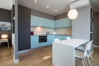 a kitchen with blue cabinets and a table and chairs at 607 Galé Apartamento Wi-Fi, estacionamento in Porto