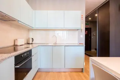 a kitchen with white cabinets and a sink at 418 Apartamento Galé wifi, estacionamento, elevador in Porto