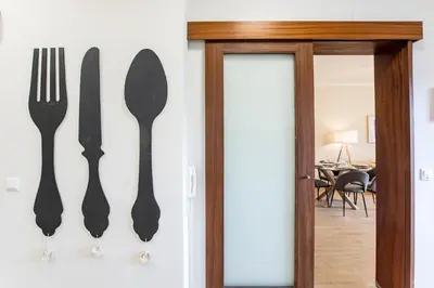 a knife fork and spoon hanging on a wall at 2BR Flat in Bonfim w/ AC & Balcony by LovelyStay in Porto