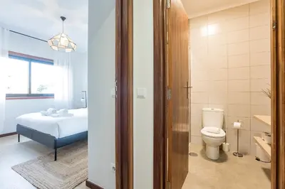 a bathroom with a bed and a toilet in a room at 2BR Flat in Bonfim w/ AC & Balcony by LovelyStay in Porto