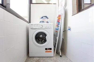 a washer and dryer in a small bathroom at 2BR Flat in Bonfim w/ AC & Balcony by LovelyStay in Porto