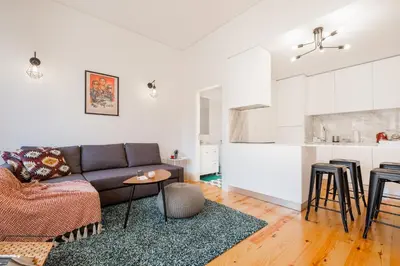 a living room with a couch and a kitchen at Oporto Shine in Porto