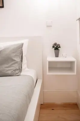 a white bedroom with a bed and a plant on a shelf at Oporto Shine in Porto