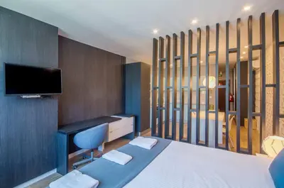 a room with a bed and a desk and a tv at 408 Galé Center Apartamento Wi-Fi, estacionamento in Porto