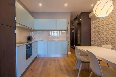 a kitchen with blue cabinets and a table with chairs at 408 Galé Center Apartamento Wi-Fi, estacionamento in Porto