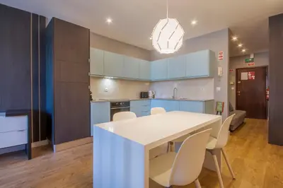 a kitchen with blue cabinets and a white table and chairs at 408 Galé Center Apartamento Wi-Fi, estacionamento in Porto