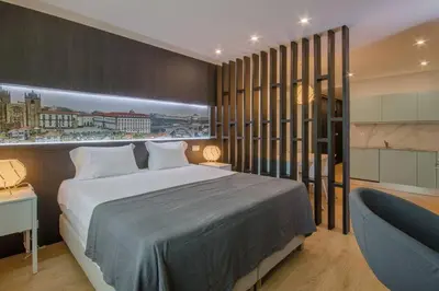 a bedroom with a large bed and a blue chair at 406 Galé Center Apartment wifi, parking in Porto