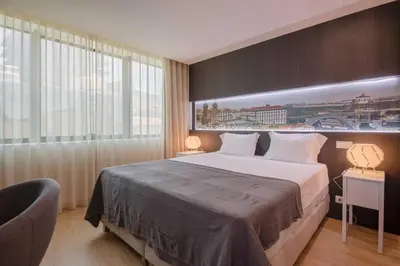 a bedroom with a large bed and a large window at 406 Galé Center Apartment wifi, parking in Porto