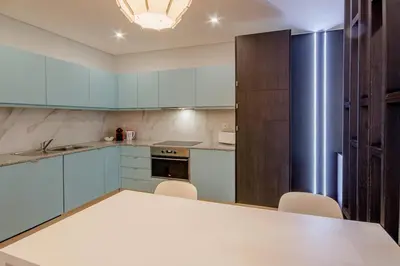 a kitchen with blue cabinets and a table and chairs at 406 Galé Center Apartment wifi, parking in Porto