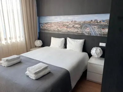 a bedroom with a large bed with towels on it at 411 Galé Center Apartamento Wi-Fi, estacionamento in Porto