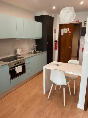 a kitchen with a white table and white chairs at 411 Galé Center Apartamento Wi-Fi, estacionamento in Porto