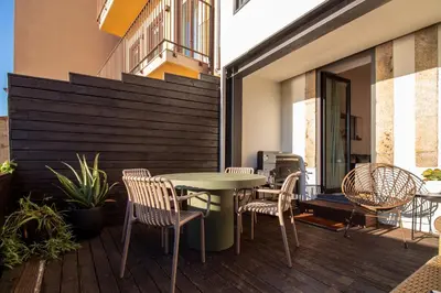 a patio with a table and chairs on a deck at Luxurious Townhome with River View by LovelyStay in Porto