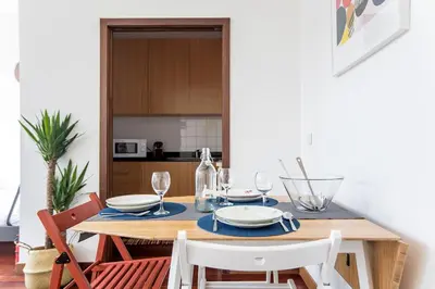 a dining room with a wooden table and chairs at Bonjardim Studio w/ Balcony by LovelyStay in Porto