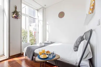 a bedroom with a bed and a table with drinks on it at Bonjardim Studio w/ Balcony by LovelyStay in Porto