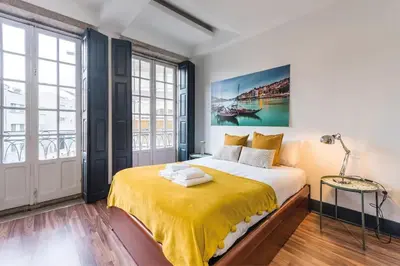 a bedroom with a large bed with a yellow blanket at Papa 1T · Papa Studio Central Garden View in Porto